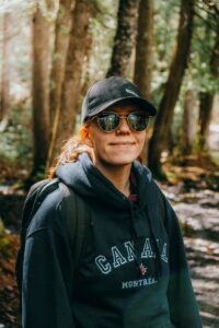Woman wearing a canada hoodie and sunglasses in woods